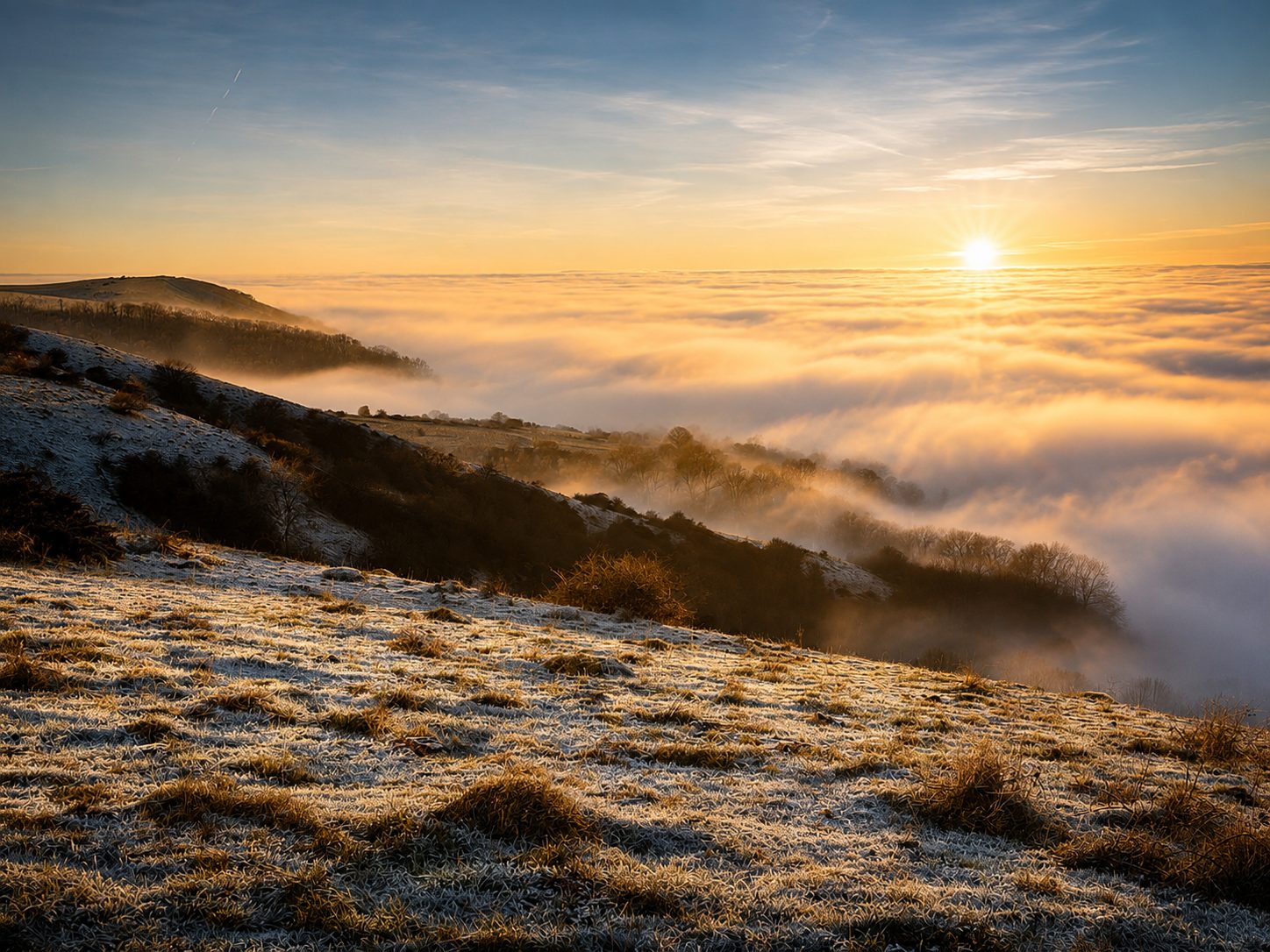 Sunrise above a sea of mist from the top of the Downs